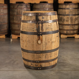 
                  
                    Side of a used 4 year Wild Turkey Bourbon barrel with other barrels stacked on pallets in the background
                  
                