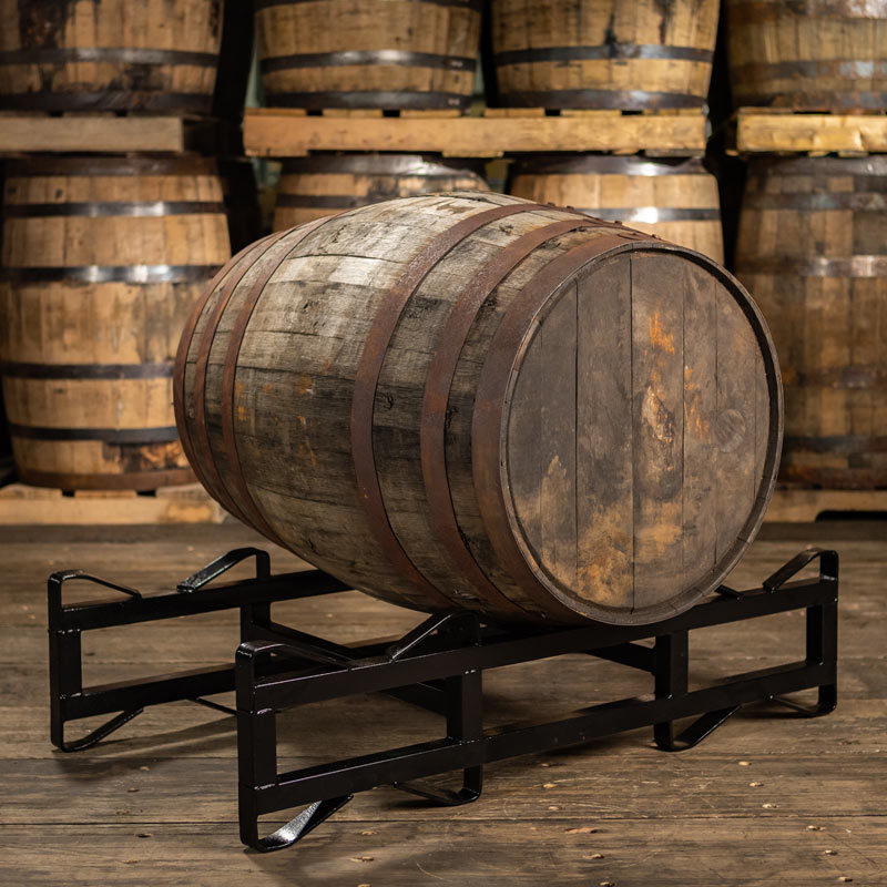 Barbados rum barrel ex bourbon on a rack with barrels stacked on pallets in the background