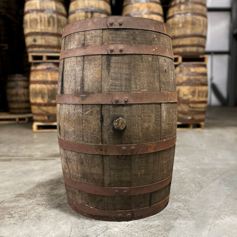 
                  
                    Side with belly bung of a Virgin Islands Rum Barrel and other used barrels stacked in the background
                  
                