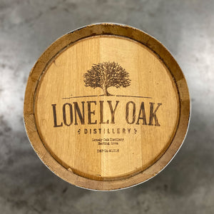 
                  
                    Head of a 5 Gallon Lonely Oak Bourbon Barrel with tree and Lonely Oak Distillery Earling, Iowa engraved on the head
                  
                