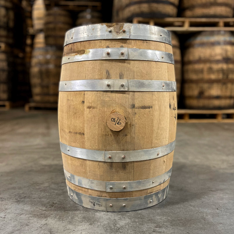 Side of a 10 Gallon Lonely Oak Rum Barrel with other used barrels on pallets in the background