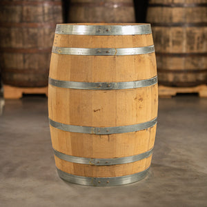 
                  
                    Side of a 30 Gallon Old Line Spirits Single Malt Whiskey Barrel with shiny, steel rings and other used whiskey barrels on pallets in the background
                  
                