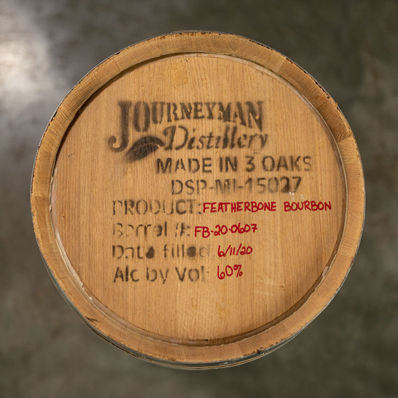 Head of a 15 Gallon Journeyman Distillery Bourbon barrel with logo and information stamped and written on the barrel head