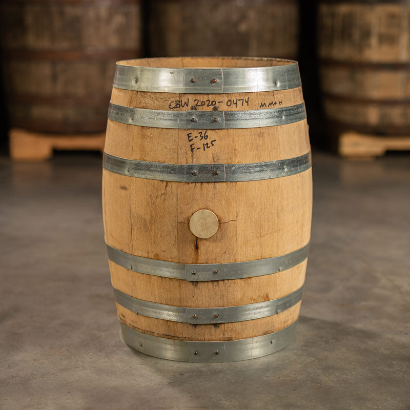 Side of a 10 Gallon Reservoir Distillery Bourbon barrel with other barrels on pallets in the background