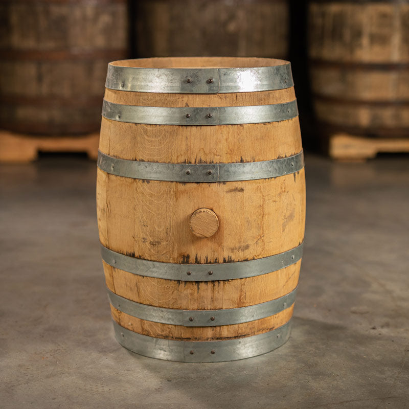 Side of a 10 Gallon Reservoir Distillery Rye Whiskey barrel with other used whiskey barrels on pallets in the background