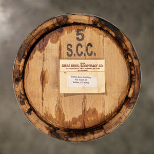 
                  
                    Head of a 5 Gallon Golden Moon Distillery Whiskey barrel with Gibbs Brothers Cooperage sticker and 5 SCC stamped on the head
                  
                