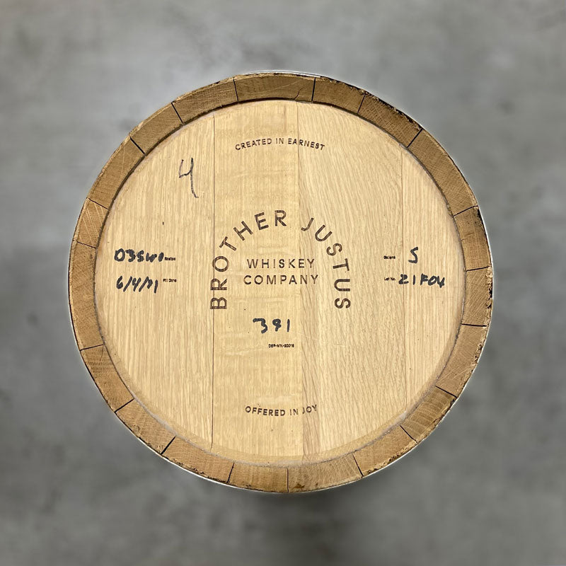 Head of a Brother Justice Single Malt Whiskey barrel with Brother Justus Whiskey Company, Crafted in Earnest Offered in Joy engraved on the head and handwritten whiskey info