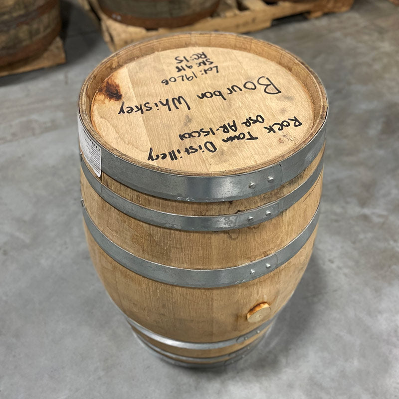 Head and side with bung of a 15 Gallon Rock Town Distillery Bourbon Whiskey Barrel with handwritten information and barrel age on the head.