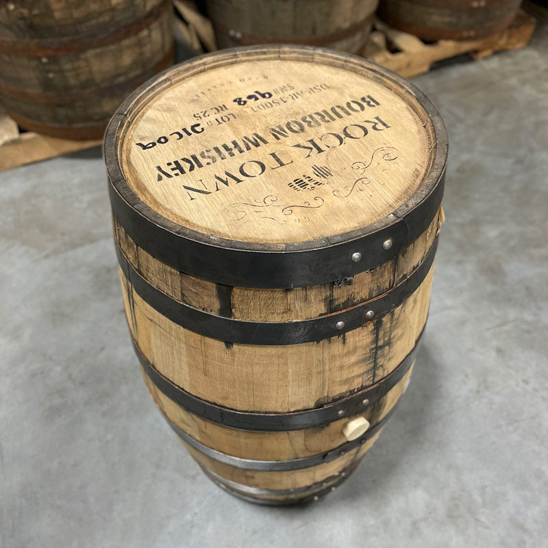 
                  
                    Side with bung and head of a 25 Gallon Rock Town Distillery Bourbon Whiskey Barrel with decorative barrel design, distillery information and barrel age on the head.
                  
                