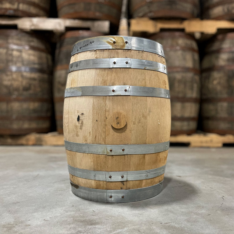 Side and bung of a 10 Gallon Re:Find Distillery Whiskey Barrel and full size used barrels in the background