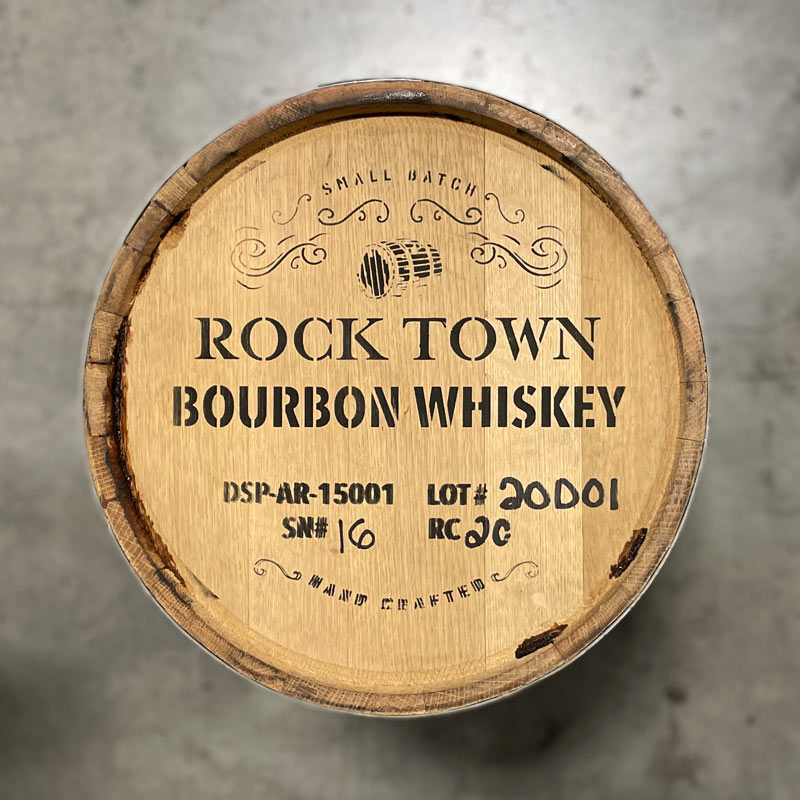 Head of a 20 Gallon Rock Town Bourbon Whiskey Barrel with stamp that says "Small Batch Rock Town Bourbon Whiskey Hand Crafted" with additional distillery notes, an image of a barrel and fancy upper border decoration 