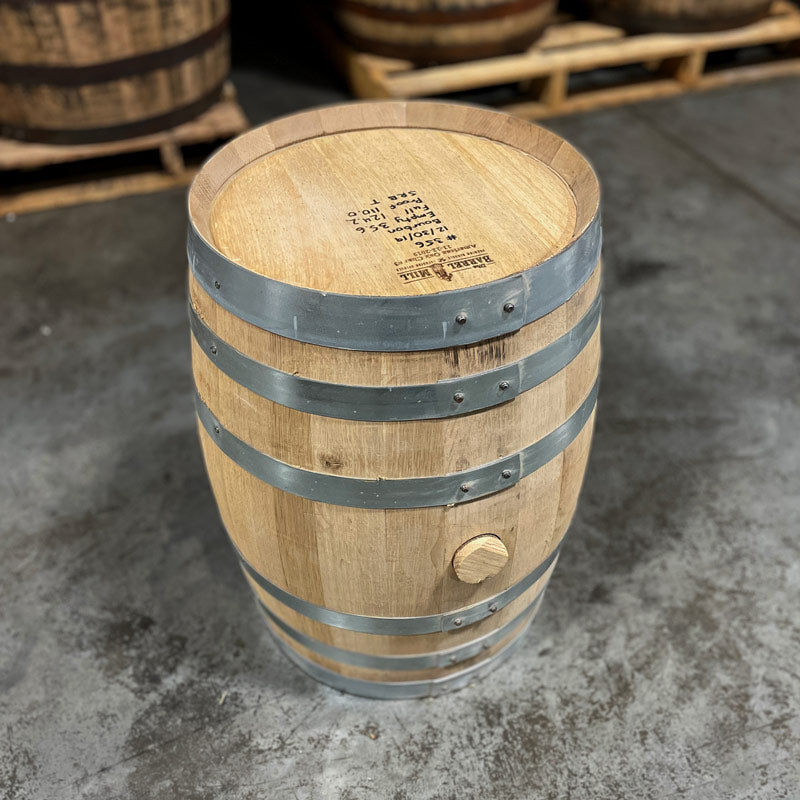 
                  
                    Head with handwritten notes and side with bung of a 10 Gallon Lonely Oak Bourbon Barrel with other used barrels on pallets in the background
                  
                