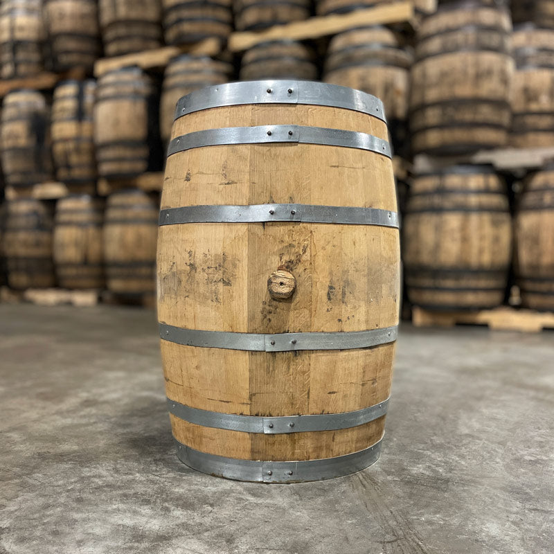 Side with bung of a 30 Gallon West Fork Wheated Bourbon Barrel with other used barrels in the background