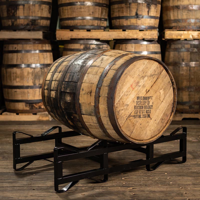 
                  
                    Wild Turkey Bourbon Barrel with distillery information stamped on the head and laying on a barrel rack
                  
                
