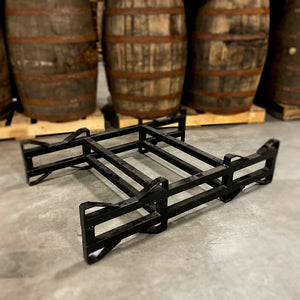 
                  
                    Used, black 2-barrel steel rack with 3-inch clearance height on floor in front of barrels stacked on pallets
                  
                