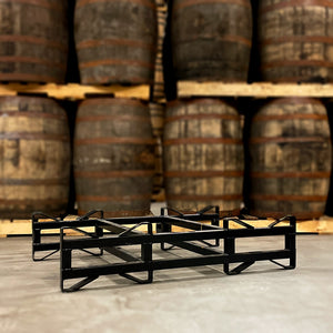 
                  
                    Used, black 2-barrel steel rack with 3-inch clearance height on floor in front of barrels stacked on pallets
                  
                
