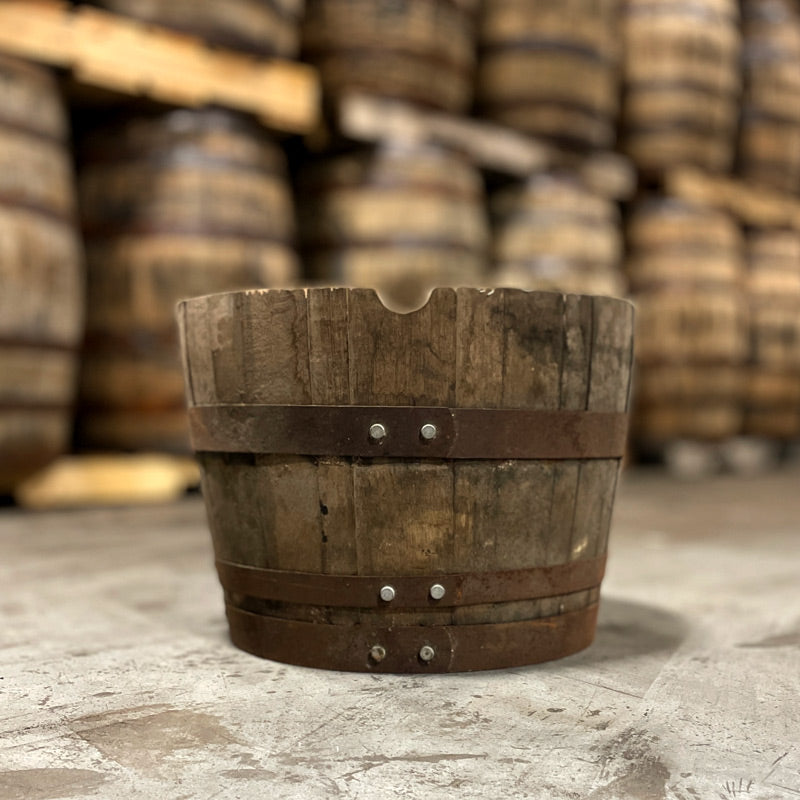
                  
                    A 15 gallon whiskey barrel cut in half with a charred interior to be used as a planter and other barrels in the background
                  
                