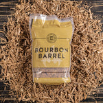 A bag full of Bourbon Barrel BBQ Smoking Wood Chips with used bourbon barrels in the background with loose chips around it