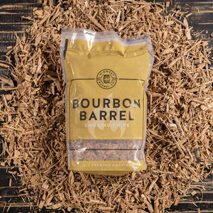 
                  
                    A bag full of Bourbon Barrel BBQ Smoking Wood Chips with used bourbon barrels in the background with loose chips around it
                  
                