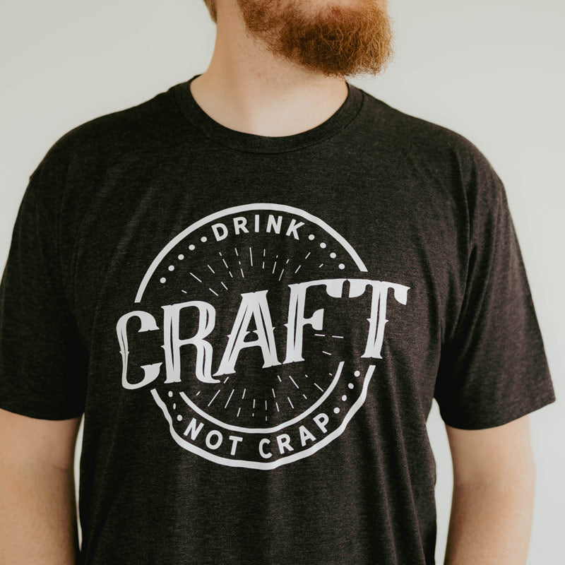 charcoal gray t-shirt with circle design that says drink craft not crap