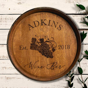 
                  
                    Engraved wine barrel head with Adkins Wine Bar Est. 2018 and an image of grapes on the vine
                  
                