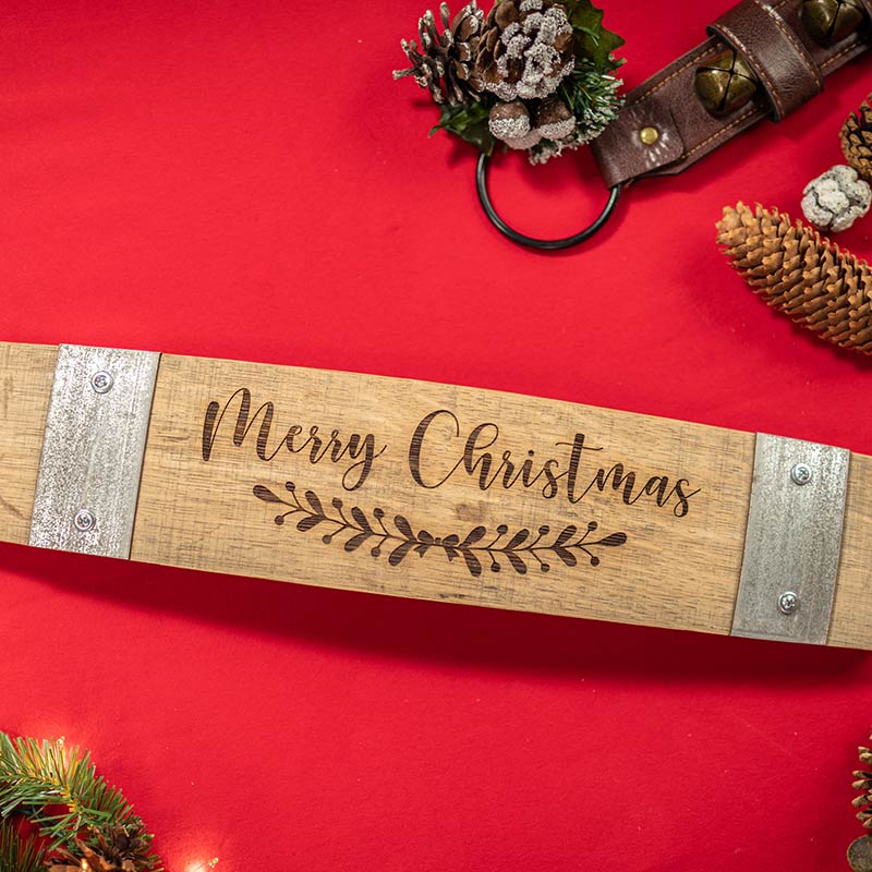 Laser engraved wine barrel stave with steel bands screwed onto both ends and Merry Christmas floral design