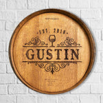 Engraved barrel head with Gustin Est. 2018 wine glass and ornate designs hanging on a wall