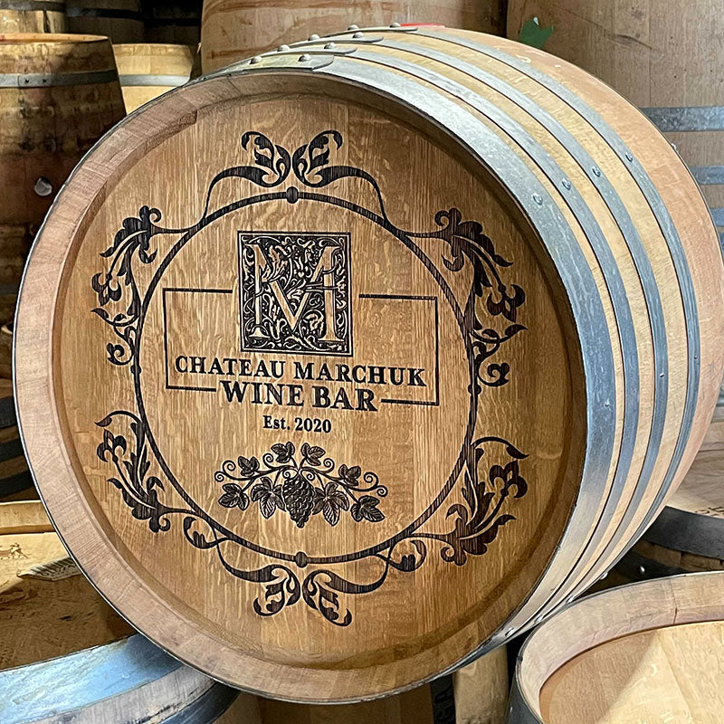 Example 2 of a custom laser engraved wine barrel with M Chateau Marchuk Wine Bar Est. 2020 and grape vines circle design