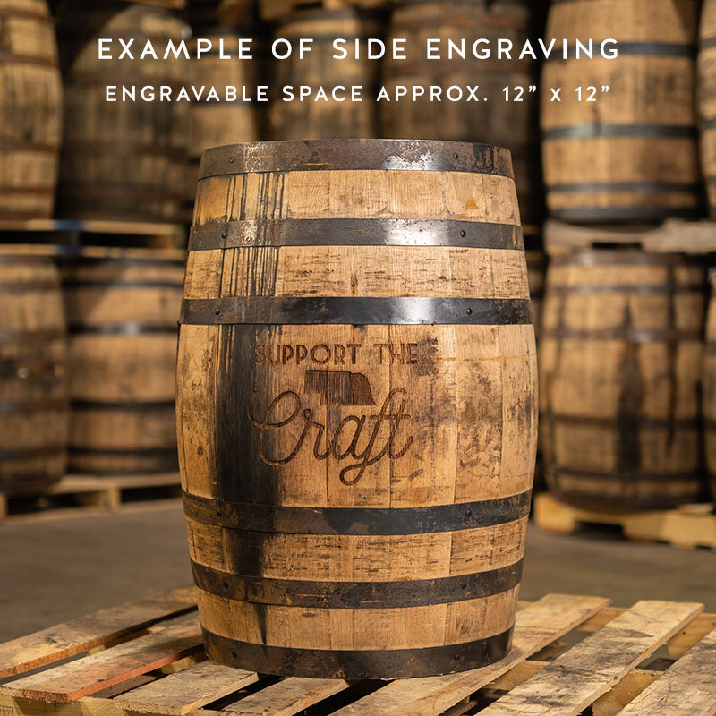 Example of side engraving engravable space approx. 12" by 12" with picture of an engraved whiskey barrel with Support the Craft and state of Nebraska engraved on the side and other used whiskey barrels stacked on pallets in the background