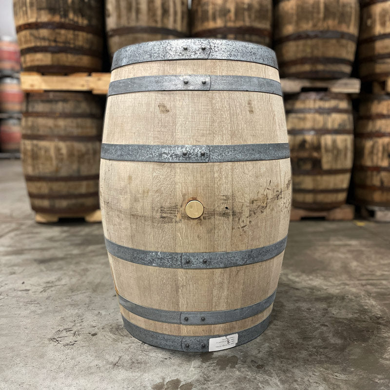 Bung side of a Hangar 1 Grape Brandy Barrel (Ex-Wine) with used whiskey barrels in the background