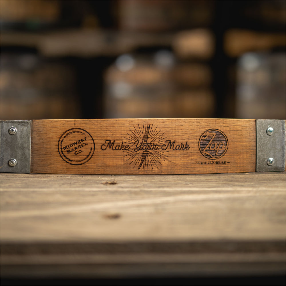 Custom logos engraved onto a wine barrel stave with steel bands screwed onto either end