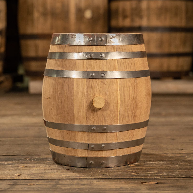 
                  
                    Brand new 5 gallon white oak barrel with shiny steel rings and clean staves with large barrels in the background
                  
                